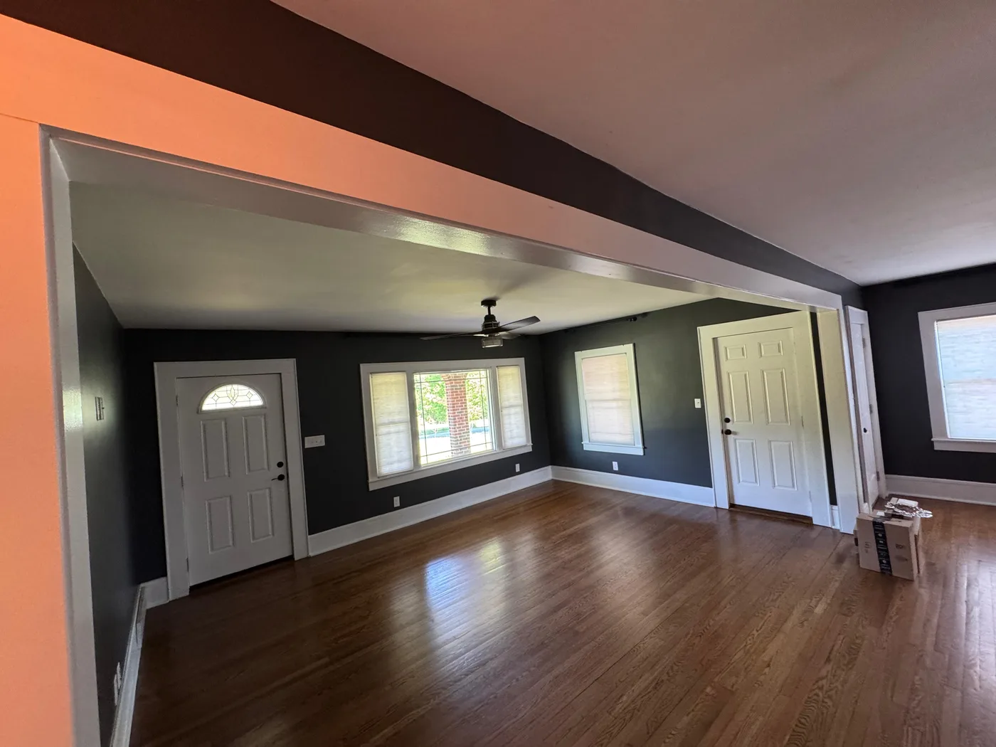 Remodeled living room with dramatic dark walls and refinished floors